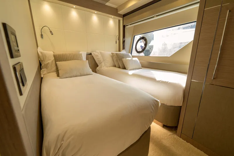 Lady M Yacht Photos Pics Luxurious twin bedroom in 2019 Sunseeker 76 Yacht, featuring elegant decor and ample natural light.