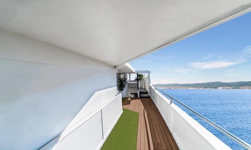  Yacht Photos Pics Spacious yacht deck with ocean view, featuring wooden flooring and green carpet, Custom 42, 1983.