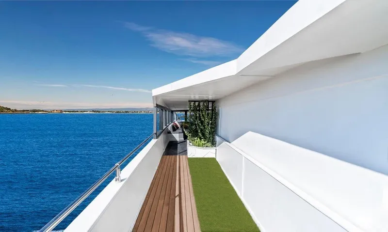  Yacht Photos Pics Luxurious yacht deck with ocean view, featuring wooden flooring and greenery, Custom model 42, 1983.