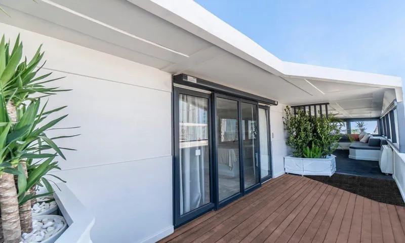  Yacht Photos Pics Modern houseboat deck with sliding glass doors, potted plants, and wooden flooring. Custom model 42, 1983.