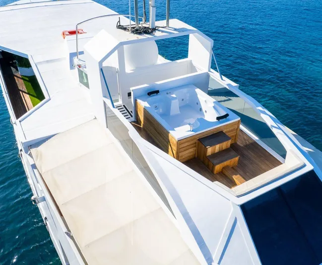  Yacht Photos Pics Luxurious custom yacht with jacuzzi on deck, cruising in clear blue waters.