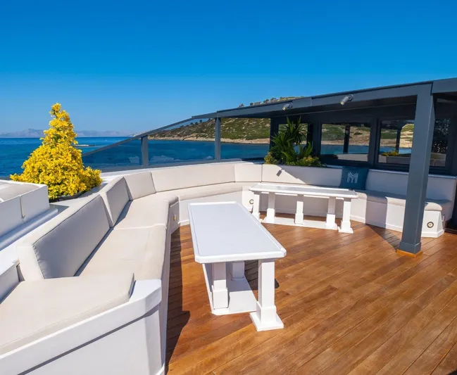  Yacht Photos Pics Luxurious yacht deck with white seating, wooden flooring, and ocean view. Custom model 42, 1983.