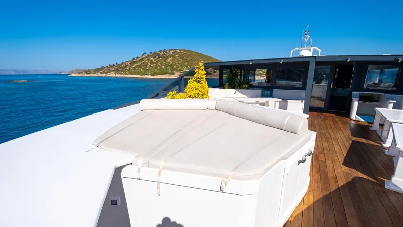  Yacht Photos Pics Luxurious yacht deck with ocean view, featuring sunbathing area and wooden flooring, Custom 42 model.