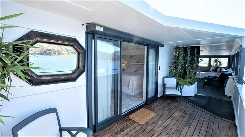  Yacht Photos Pics Luxurious yacht interior with wooden deck, sliding glass doors, and ocean view. Custom model 42, 1983.