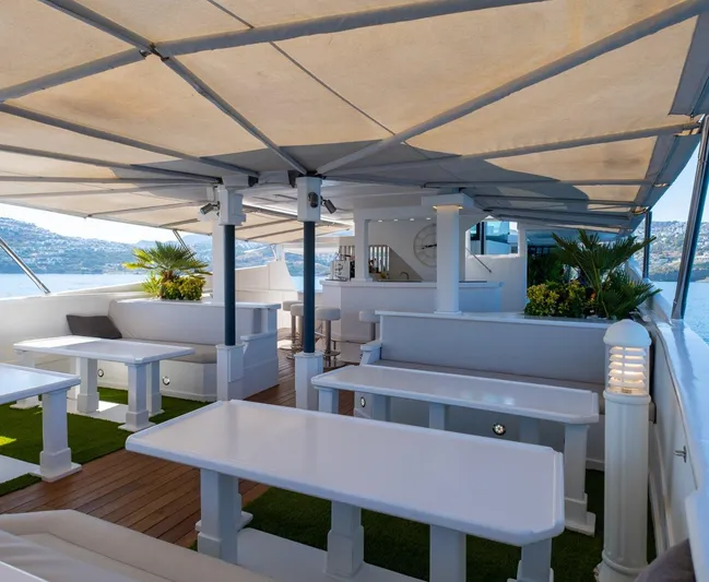  Yacht Photos Pics Luxurious yacht deck with white seating, shaded canopy, and ocean view, Custom model 42, 1983.