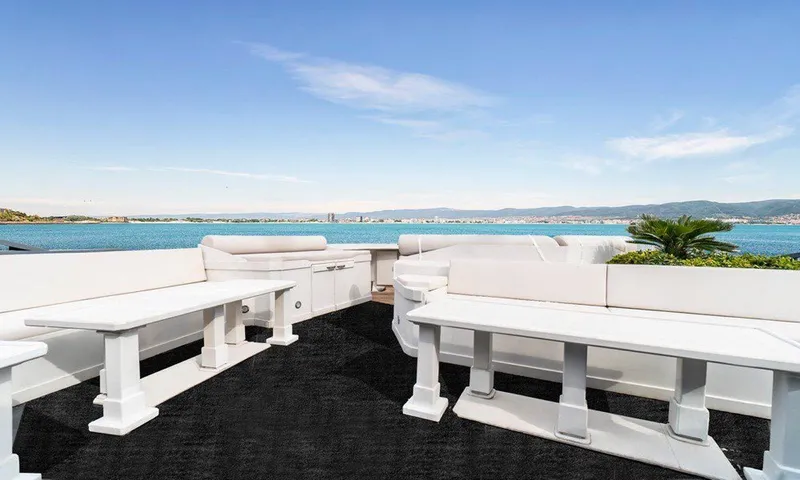  Yacht Photos Pics Luxurious yacht deck with white seating, ocean view, and clear blue sky. Custom model 42, 1983.