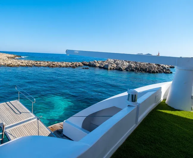  Yacht Photos Pics Luxurious yacht deck overlooking clear blue sea and rocky coastline, Custom model 42, 1983.