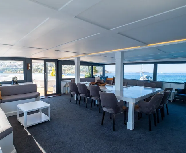  Yacht Photos Pics Spacious yacht interior with dining area, panoramic windows, and ocean view, Custom 42, 1983 model.