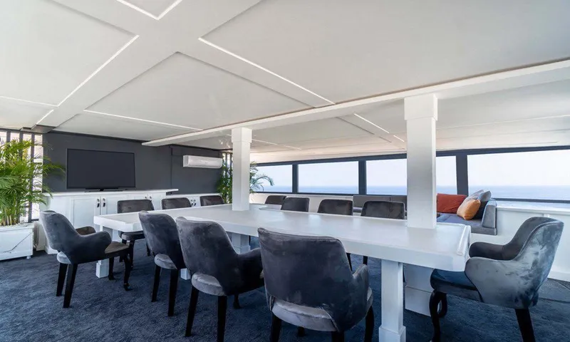  Yacht Photos Pics Luxurious yacht interior with elegant dining area, plush chairs, and ocean view windows.