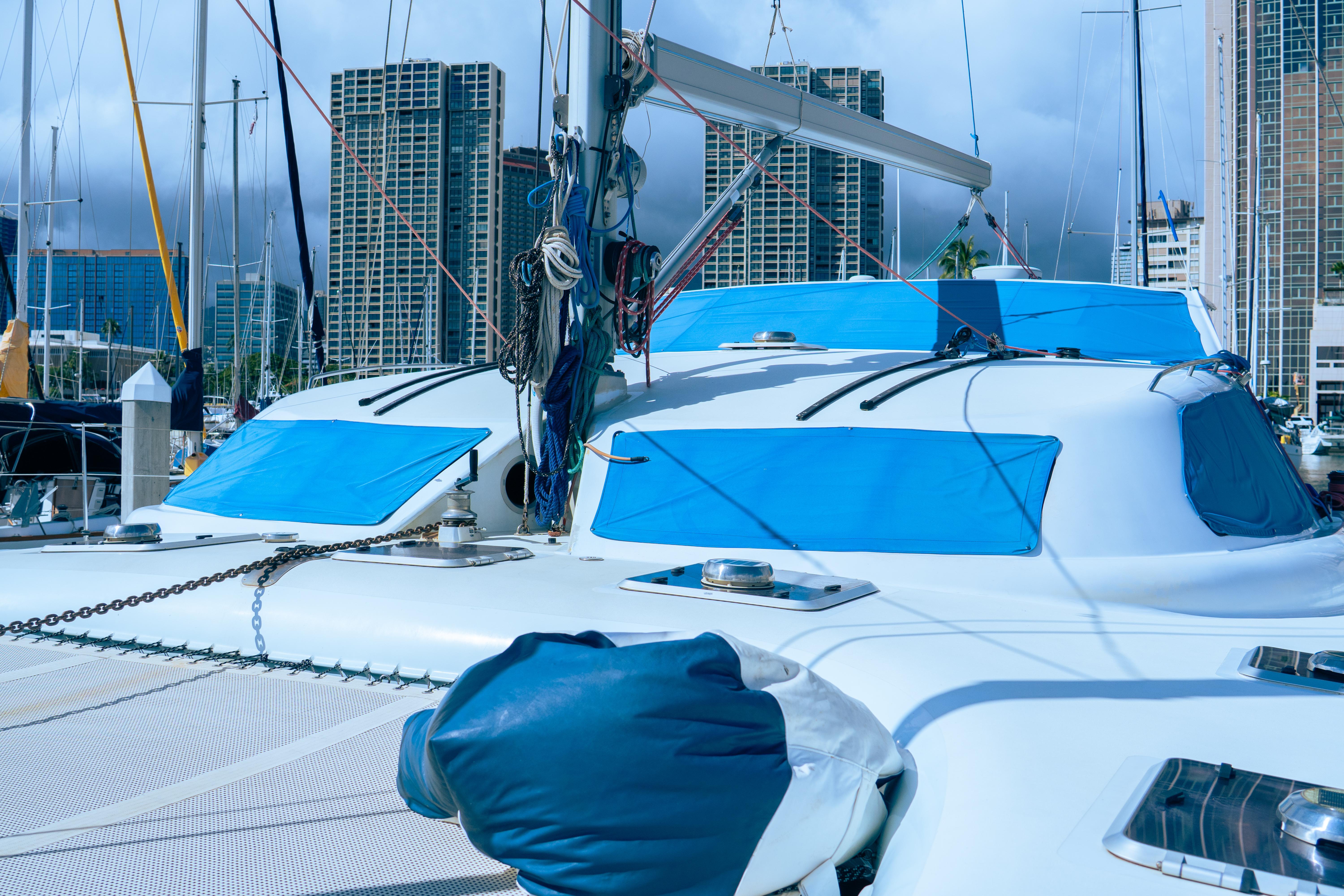 Luxury performance yacht docked in marina, city skyline in background, 2005 model.