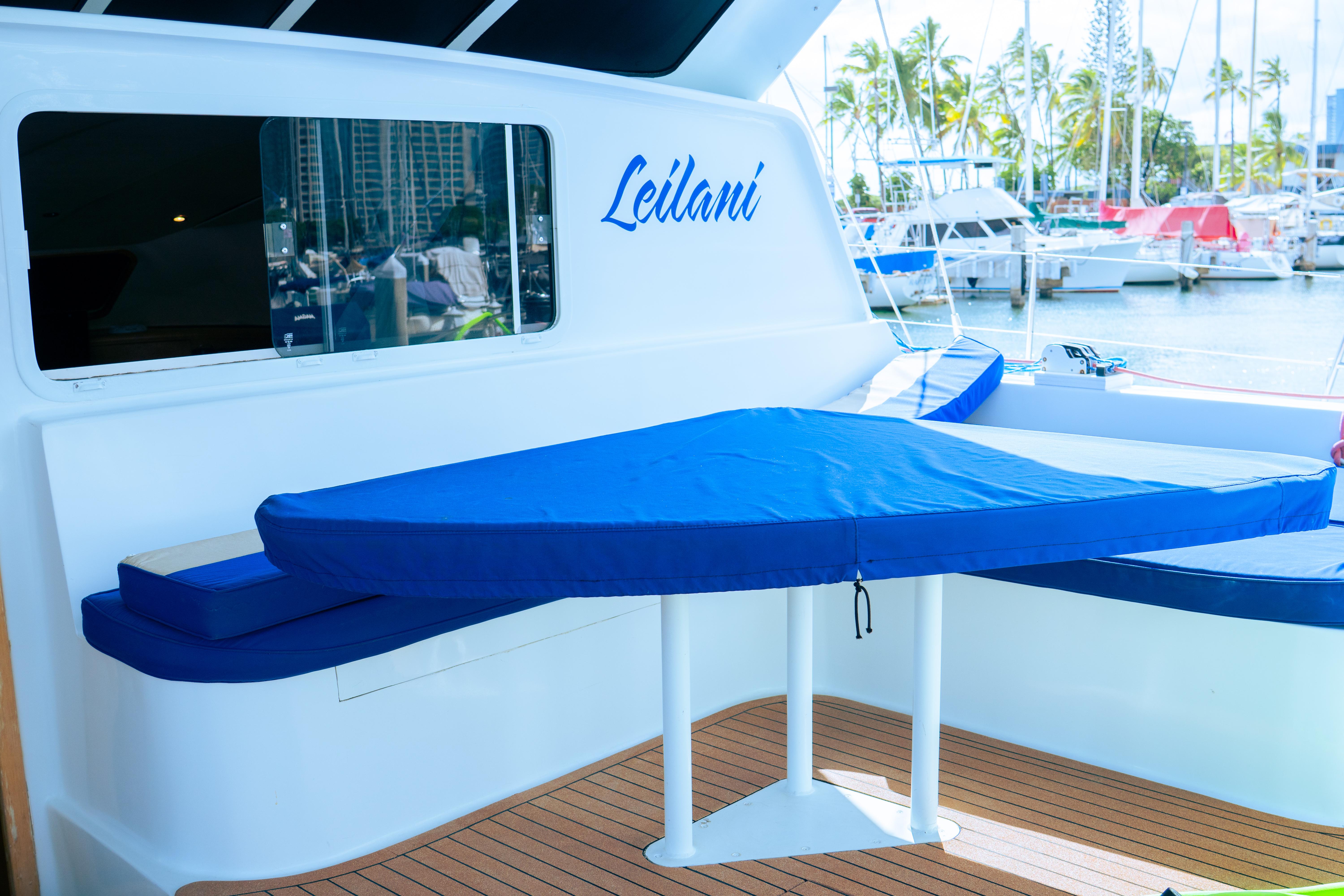 Luxury yacht deck with blue seating, marina view, 2005 Custom model.