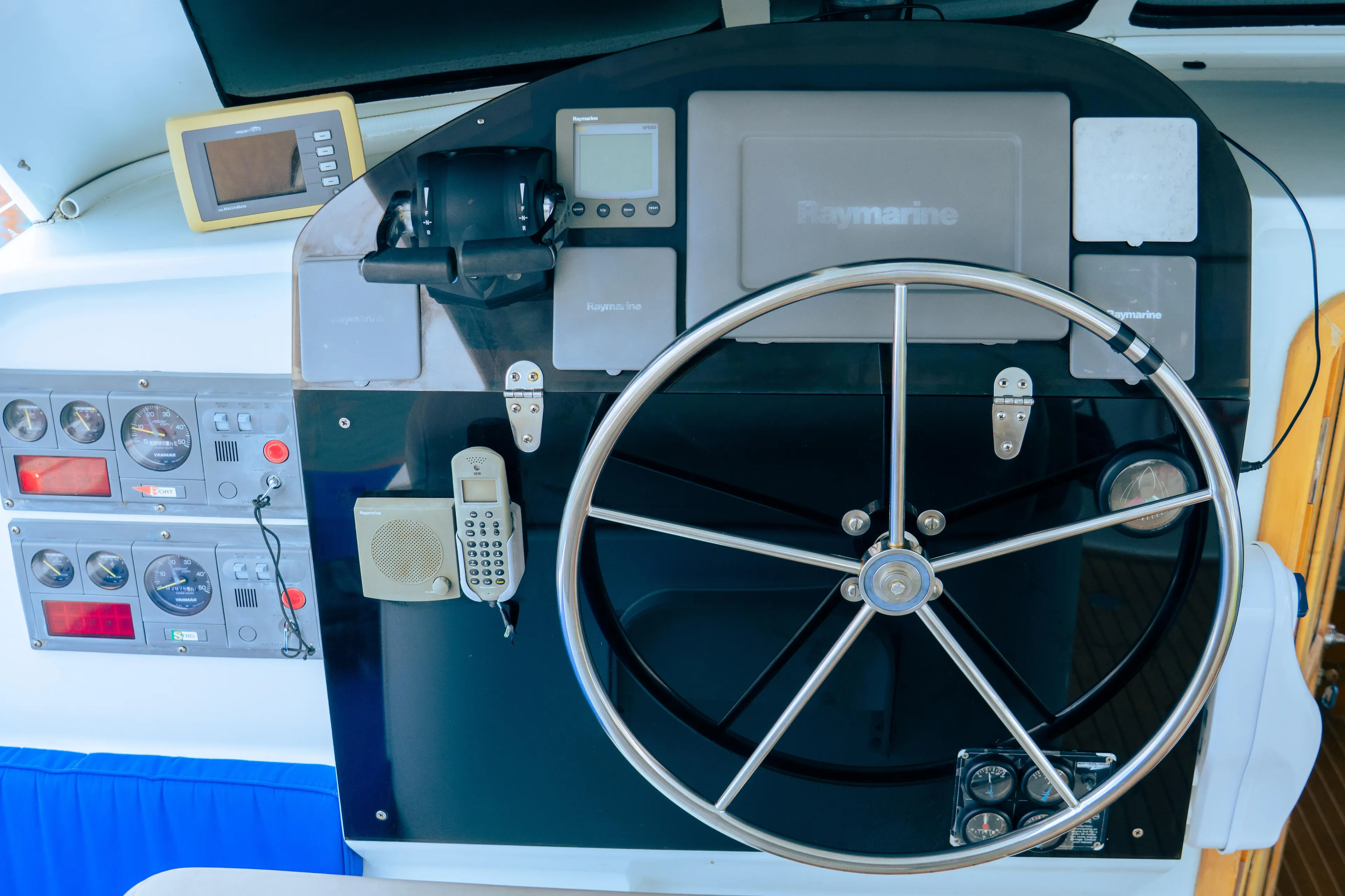 Control panel of a 2005 custom luxury performance boat with steering wheel and navigation instruments.