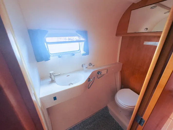 Leilani Yacht Photos Pics Compact luxury bathroom in a 2005 custom performance model, featuring sink and toilet.