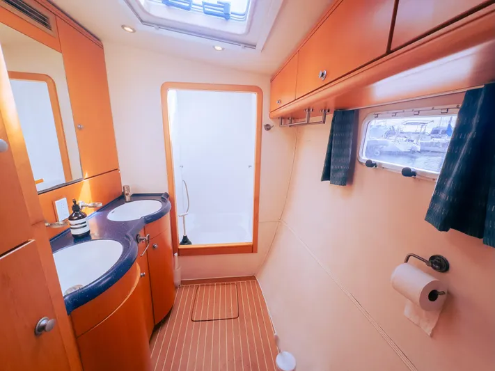 Leilani Yacht Photos Pics Luxurious yacht bathroom with dual sinks, wooden cabinetry, and a window view, 2005 model.