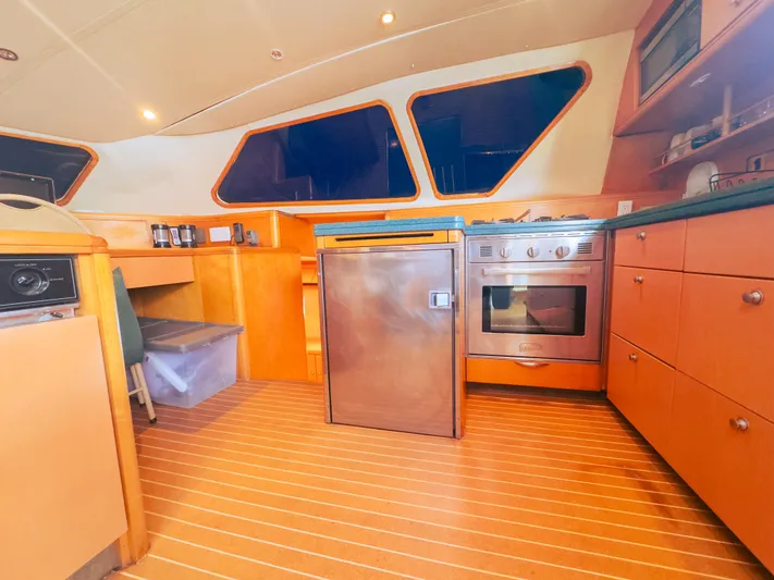 Leilani Yacht Photos Pics Luxurious yacht kitchen with modern appliances, wooden cabinetry, and sleek design, 2005 Custom model.