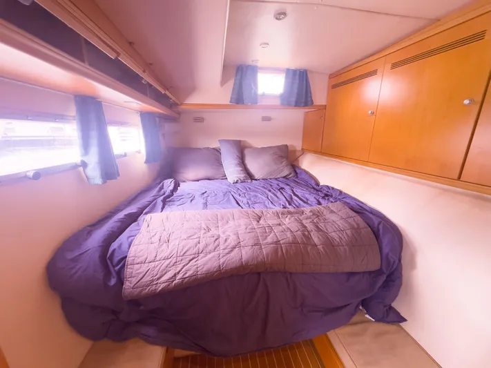 Leilani Yacht Photos Pics Luxurious 2005 custom yacht bedroom with cozy bedding and wooden cabinetry.