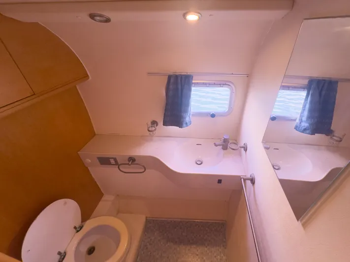 Leilani Yacht Photos Pics Luxury yacht bathroom with sink, toilet, mirror, and window, 2005 custom model.