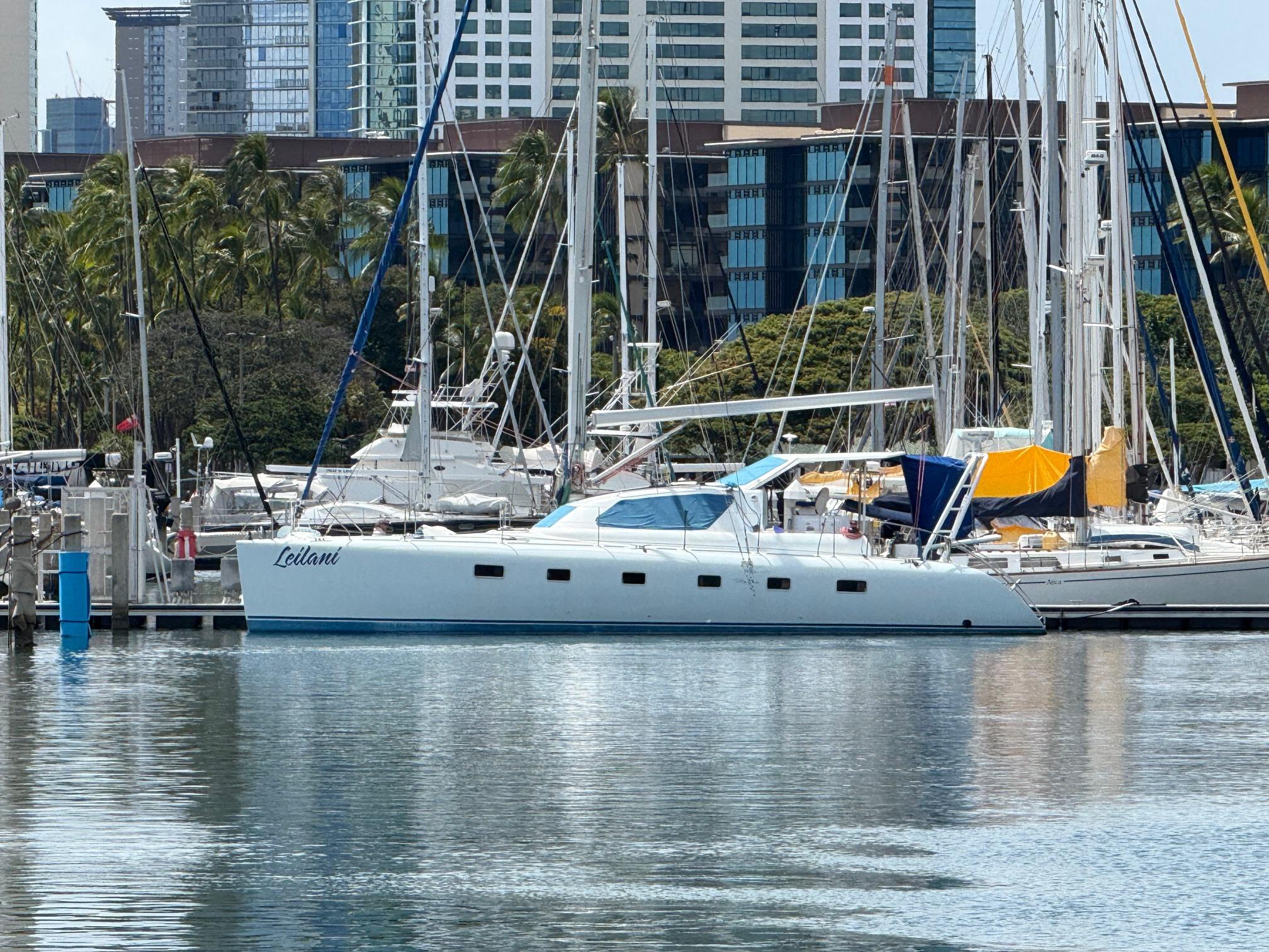 Luxury yacht docked in marina with cityscape background, 2005 custom model.