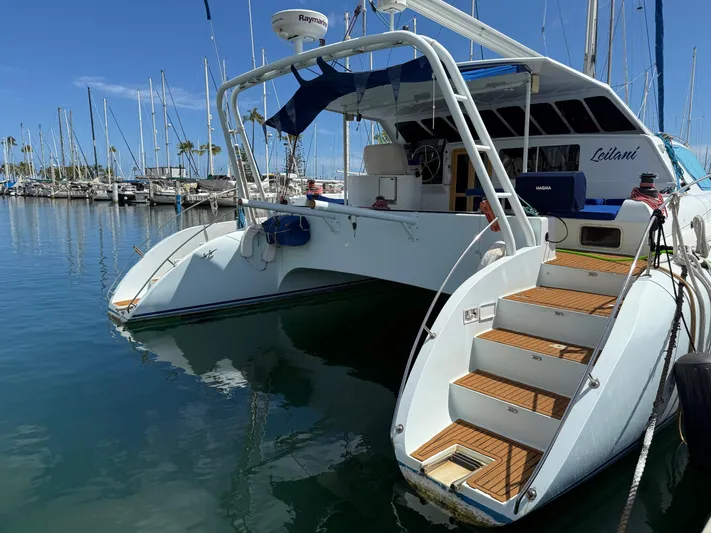 Leilani Yacht Photos Pics Luxury performance catamaran docked at marina, 2005 model, with elegant wooden steps and sleek design.