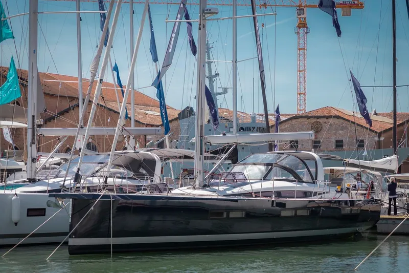  Yacht Photos Pics 2022 Jeanneau Yacht 60 docked at marina, surrounded by other sailboats and buildings.