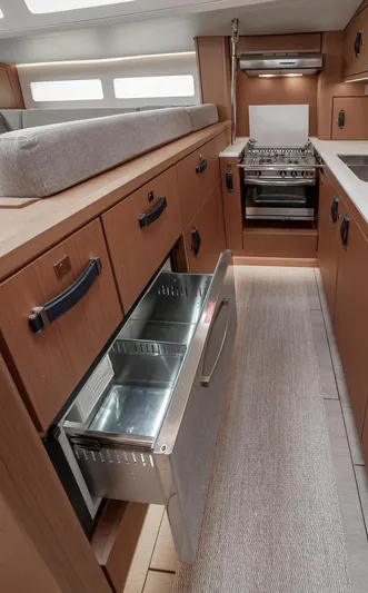  Yacht Photos Pics Modern kitchen interior of 2022 Jeanneau Yacht 60 with open drawer and stove.