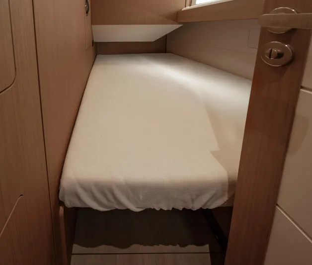  Yacht Photos Pics Cozy cabin bed in 2022 Jeanneau Yacht 60, featuring sleek wooden interior design.