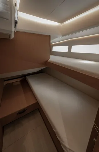  Yacht Photos Pics Cozy cabin interior of 2022 Jeanneau Yacht 60 with modern lighting and wooden finishes.