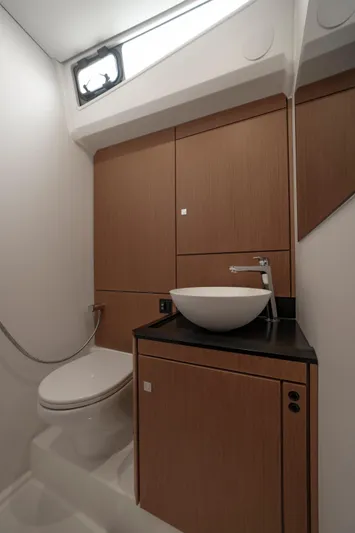  Yacht Photos Pics Modern bathroom in 2022 Jeanneau Yacht 60 with sleek fixtures and wooden cabinetry.