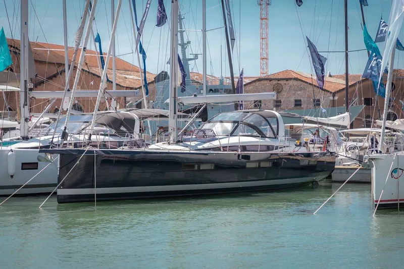  Yacht Photos Pics 2022 Jeanneau Yacht 60 docked at a marina, surrounded by other sailboats.
