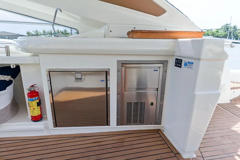 Minion Yacht Photos Pics Outdoor kitchen area on 2014 Cranchi 56 HT yacht with stainless steel appliances and fire extinguisher.