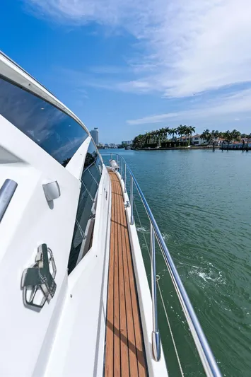 Minion Yacht Photos Pics 2014 Cranchi 56 HT yacht cruising on a sunny day, showcasing sleek design and wooden deck.