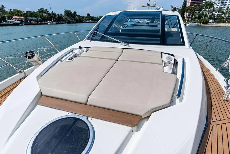 Minion Yacht Photos Pics Cranchi 56 HT 2014 yacht with sunbathing deck, docked by a scenic waterfront.