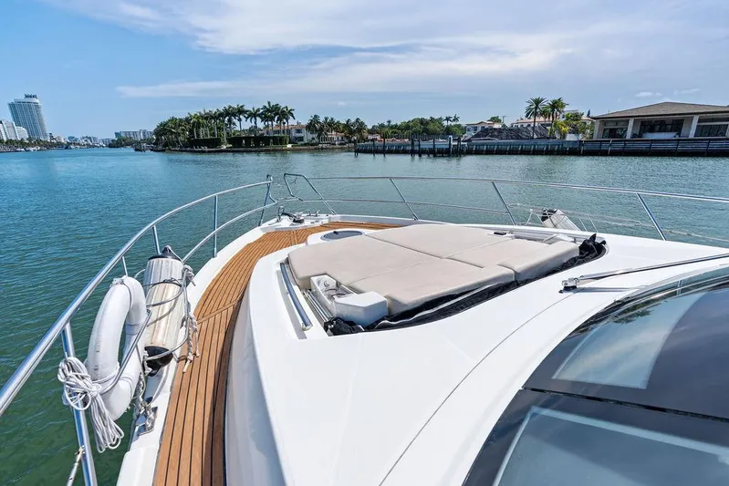 Minion Yacht Photos Pics 2014 Cranchi 56 HT yacht with sun deck, cruising near waterfront homes.