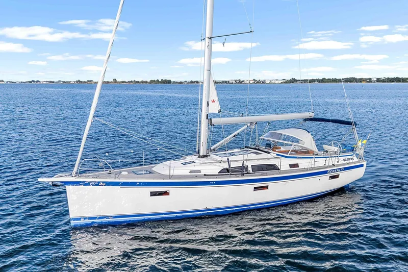  Yacht Photos Pics 2022 Hallberg-Rassy 400 sailboat on calm blue waters under a clear sky.