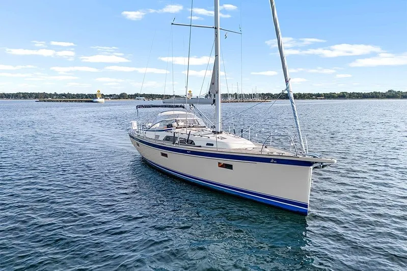  Yacht Photos Pics 2022 Hallberg-Rassy 400 sailboat on calm water under a clear blue sky.