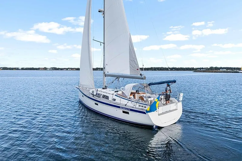  Yacht Photos Pics 2022 Hallberg-Rassy 400 sailboat cruising on calm waters under a clear blue sky.