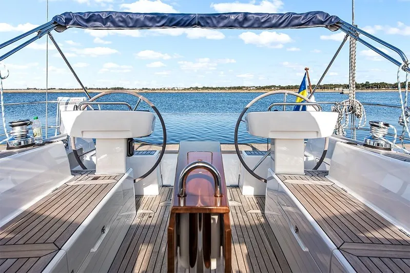  Yacht Photos Pics 2022 Hallberg-Rassy 400 yacht cockpit with dual steering wheels and scenic ocean view.