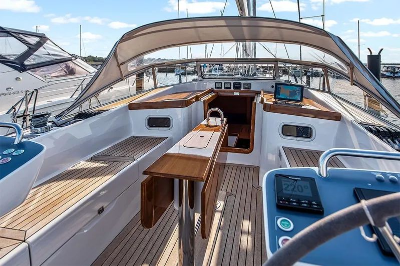  Yacht Photos Pics 2022 Hallberg-Rassy 400 yacht cockpit with wooden accents and navigation equipment.