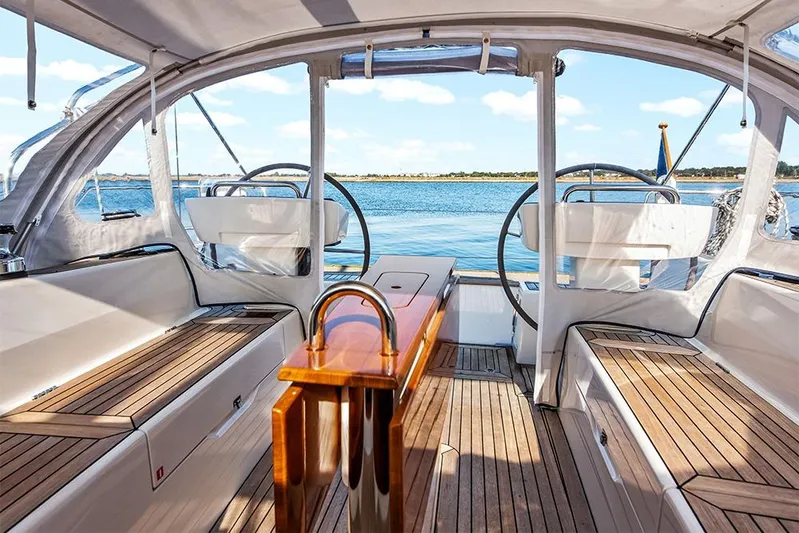  Yacht Photos Pics Luxurious 2022 Hallberg-Rassy 400 yacht interior with dual steering wheels and wooden deck.