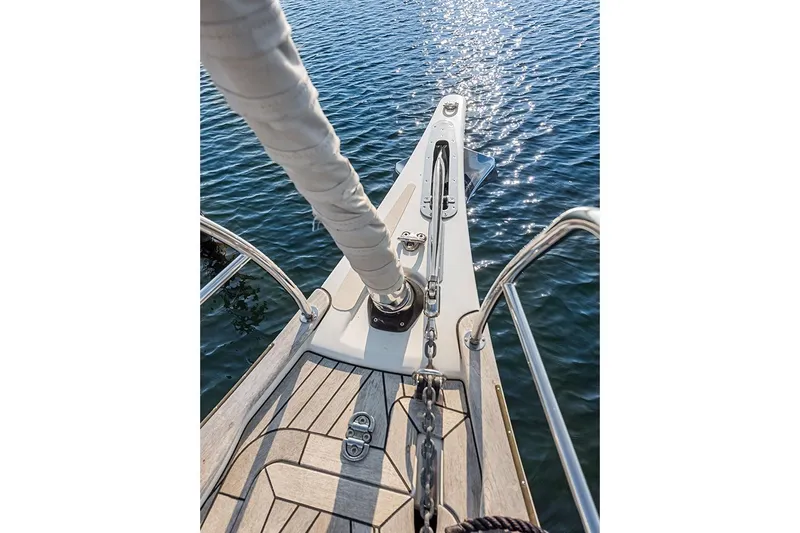  Yacht Photos Pics Bow of 2022 Hallberg-Rassy 400 yacht with anchor chain, on calm water.