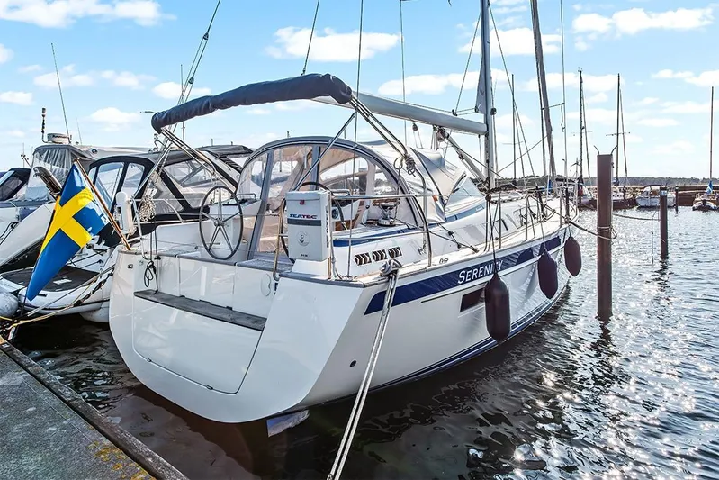  Yacht Photos Pics 2022 Hallberg-Rassy 400 sailboat docked, featuring Swedish flag and serene marina setting.