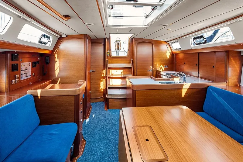  Yacht Photos Pics Interior of 2022 Hallberg-Rassy 400 yacht with wooden finish and blue seating.