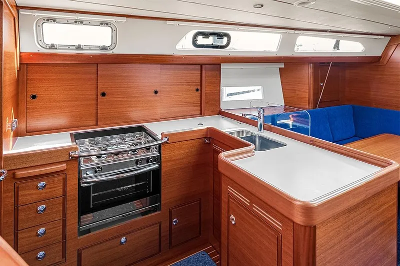  Yacht Photos Pics Luxurious 2022 Hallberg-Rassy 400 yacht interior with modern kitchen and seating area.