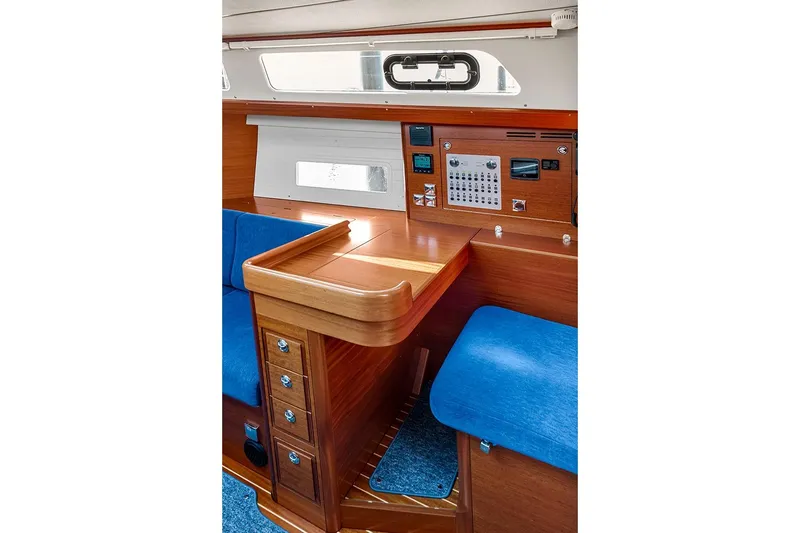  Yacht Photos Pics Interior of 2022 Hallberg-Rassy 400 yacht with wooden finish and blue seating.