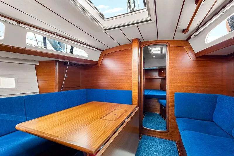  Yacht Photos Pics Interior of 2022 Hallberg-Rassy 400 yacht with blue seating and wooden finishes.