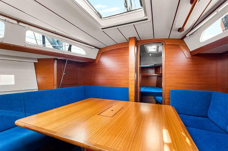  Yacht Photos Pics Interior of 2022 Hallberg-Rassy 400 yacht with wooden finish and blue seating.