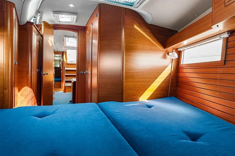  Yacht Photos Pics Interior of 2022 Hallberg-Rassy 400 yacht with wooden finish and blue upholstery.