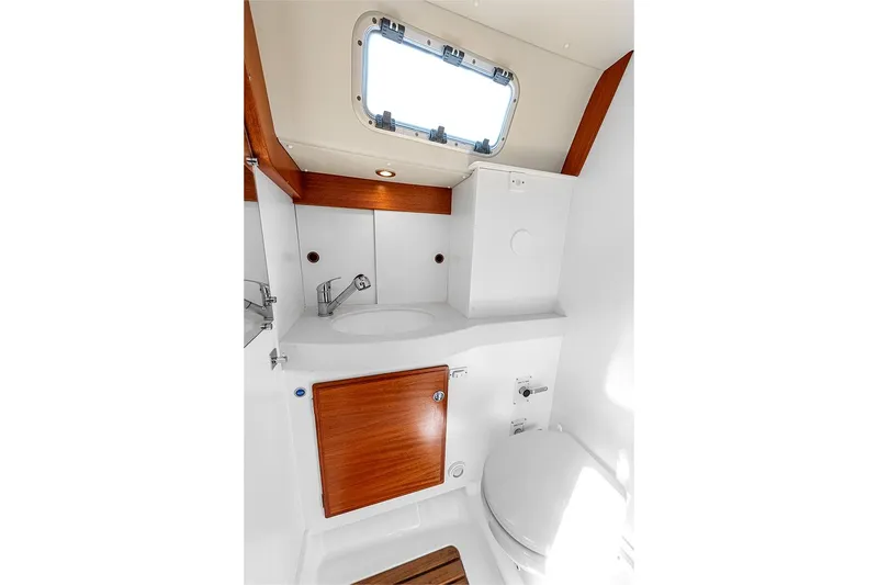  Yacht Photos Pics 2022 Hallberg-Rassy 400 yacht bathroom with modern fixtures and wooden accents.