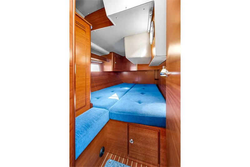  Yacht Photos Pics Interior of 2022 Hallberg-Rassy 400 yacht with blue cushioned seating and wooden finish.