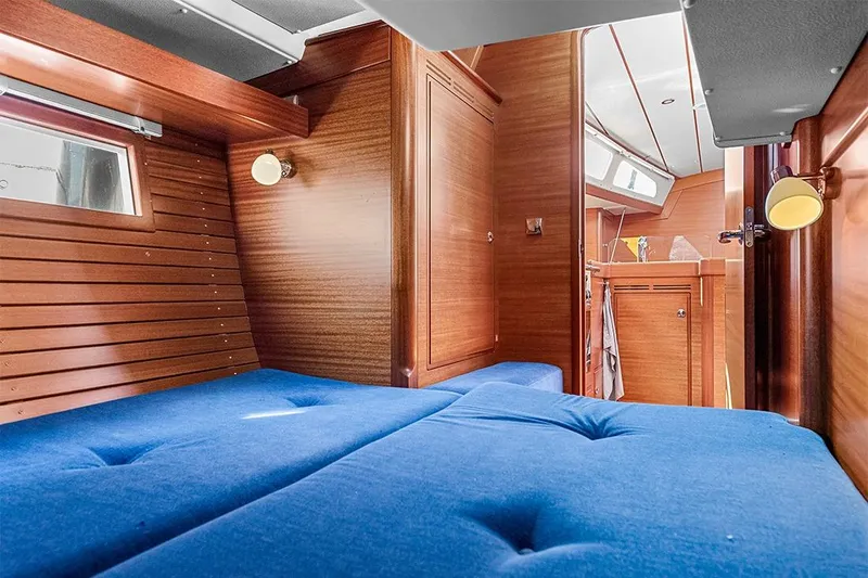  Yacht Photos Pics Interior of 2022 Hallberg-Rassy 400 yacht with blue cushioned seating and wooden finish.